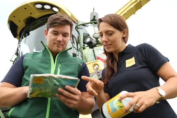 Man and woman looking at envelope of Josilac inoculants